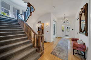 Entrance foyer with a notable chandelier and light wood-type flooring