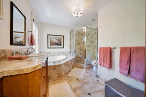 Full bathroom with plus walk in shower, vanity, and separate tub.