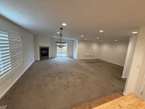 Unfurnished living room with carpet and a tiled fireplace