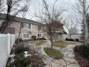 Rear view of house with central AC and a yard