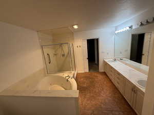 Bathroom with vanity, plus walk in shower, and a textured ceiling