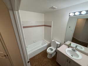 Full bathroom featuring vanity,  shower combination, toilet, and a textured ceiling