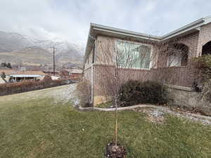 View of home's exterior with a lawn and a mountain view