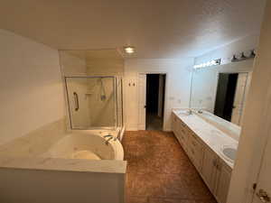 Bathroom featuring vanity, a textured ceiling, and independent shower and bath