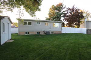 Back of property featuring a yard and cooling unit