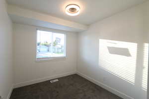 Unfurnished room with dark colored carpet