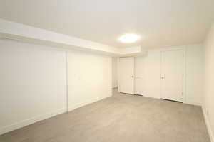 Basement with a textured ceiling and light hardwood / wood-style flooring