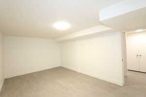 Basement featuring light hardwood / wood-style flooring and a textured ceiling