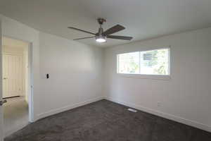 Carpeted spare room with ceiling fan