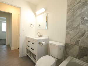 Bathroom featuring toilet, vanity, and hardwood / wood-style flooring