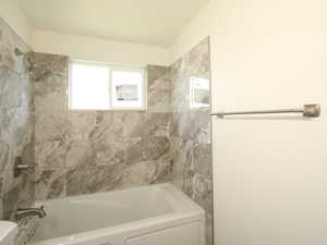 Bathroom with toilet and tiled shower / bath