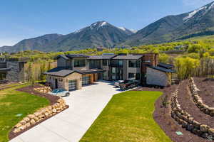 View of front of house with a mountain view, a front lawn, and a garage