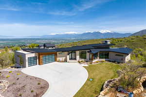 View of front of house featuring a mountain view, a garage, and a front yard