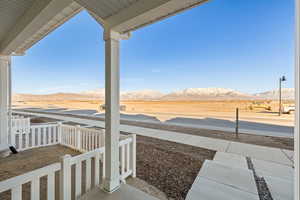 View of yard with a mountain view and covered porch