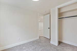 Unfurnished bedroom with a closet and light colored carpet