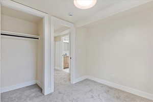 Unfurnished bedroom featuring light colored carpet and a closet