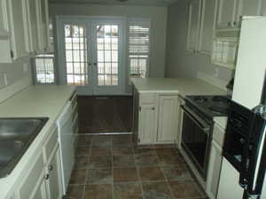 Kitchen featuring dishwasher, french doors, electric range, refrigerator with ice dispenser, and kitchen peninsula