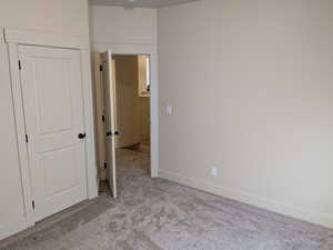 Unfurnished bedroom with a closet and light colored carpet