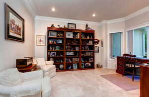 Living area with carpet floors and crown molding