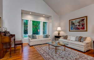 Living room with hardwood / wood-style flooring and vaulted ceiling