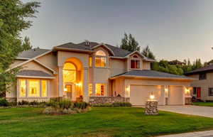 View of front of property with a yard and a garage