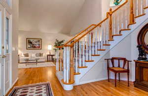 Staircase featuring hardwood / wood-style flooring and vaulted ceiling