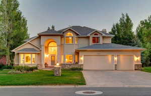 View of front of property featuring a yard and a garage