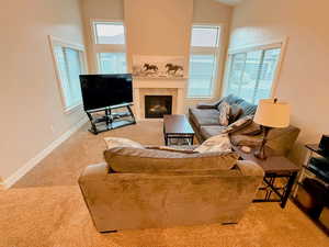 Carpeted living room with lofted ceiling and a tile fireplace