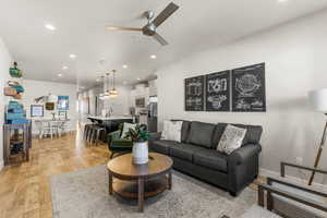 Living room with ceiling fan and light wood-type flooring