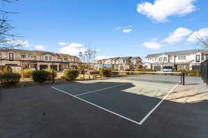 View of tennis court featuring basketball hoop