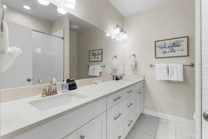 Bathroom featuring vanity and a tile shower