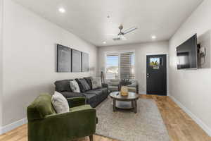 Living room featuring ceiling fan and light hardwood / wood-style flooring