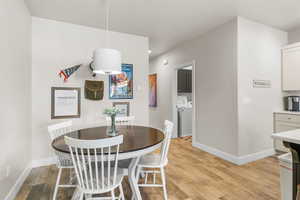 Dining space featuring washing machine and dryer and light hardwood / wood-style flooring