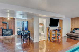 Living room with a wood stove and wooden walls