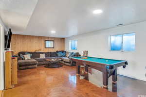 Game room with wood walls, concrete flooring, and billiards