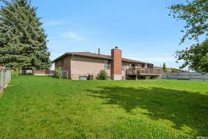 View of yard with a deck and central AC unit