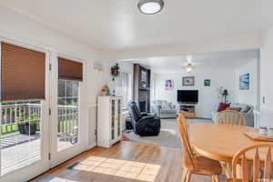 Dining space with a fireplace and light hardwood / wood-style flooring