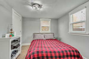 Bedroom with light carpet and a textured ceiling