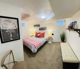 Carpeted bedroom with multiple windows and a textured ceiling