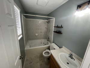 Full bathroom with tile patterned flooring, vanity, toilet, and tiled shower and jetted bath