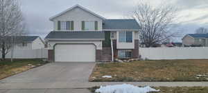 Split level home featuring a front lawn and a garage