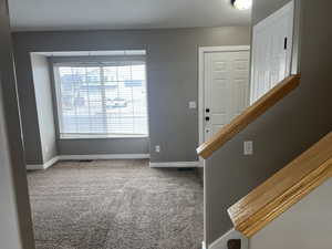 Carpeted entrance foyer with a healthy amount of sunlight