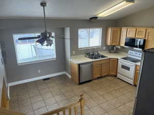 Kitchen featuring light tile patterned flooring, sink, and appliances with stainless steel finishes