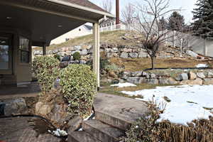 Yard covered in snow featuring a patio