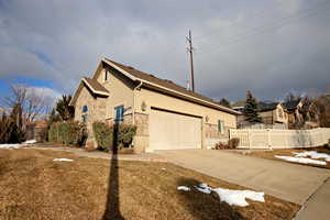 View of property exterior featuring a yard and a garage