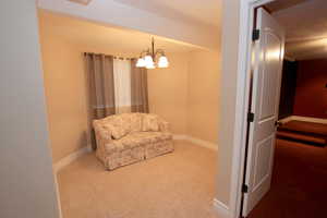 Sitting room featuring carpet flooring and a notable chandelier