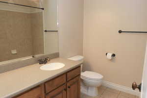 Main floor bathroom with toilet, vanity, and tile patterned floors