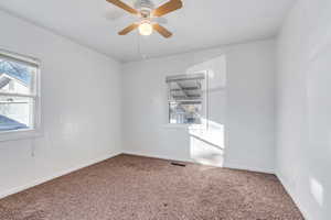 Unfurnished room featuring carpet floors and ceiling fan