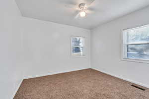 Carpeted spare room with ceiling fan