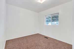 Spare room featuring carpet and a textured ceiling